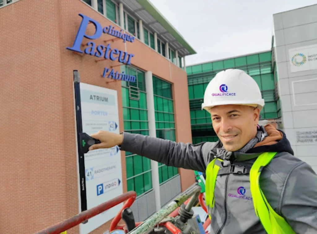 Technicien QUALIFICACE équipé devant un établissement de santé à Toulouse.