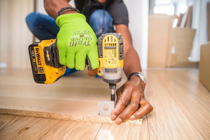 Intervenant utilisant une visseuse pour le montage d’un meuble.